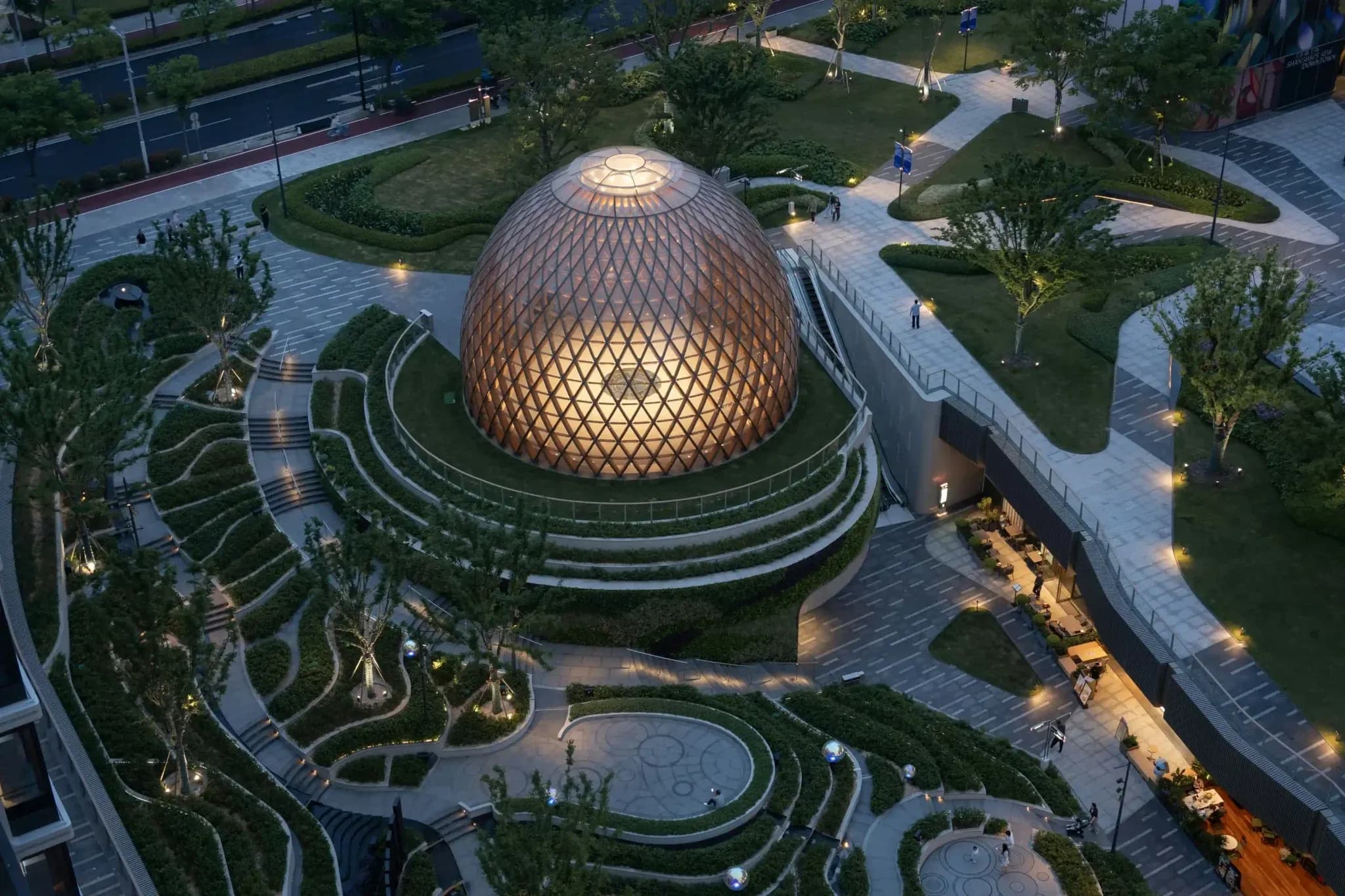 Terraced planting, pedestrian paths and water features connect The Seed with its riverfront setting in Shanghai.