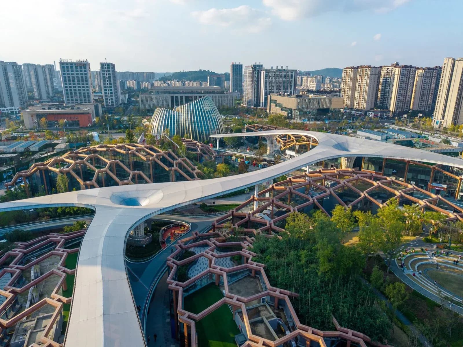 Sculptural towers inspired by bamboo rise above a layered landscape of parks, terraces and civic spaces.