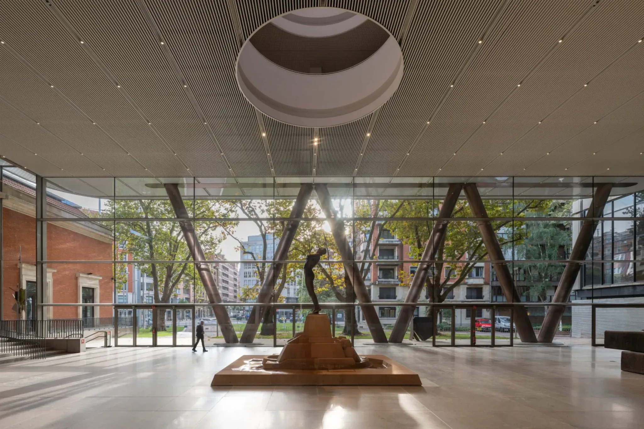 A large glazed public space sits beneath the elevated galleries.