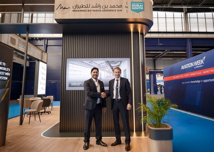 Executives from Dubai South and Phoenix Aviation shake hands on the Mohammed bin Rashid Aerospace Hub stand at MRO Europe