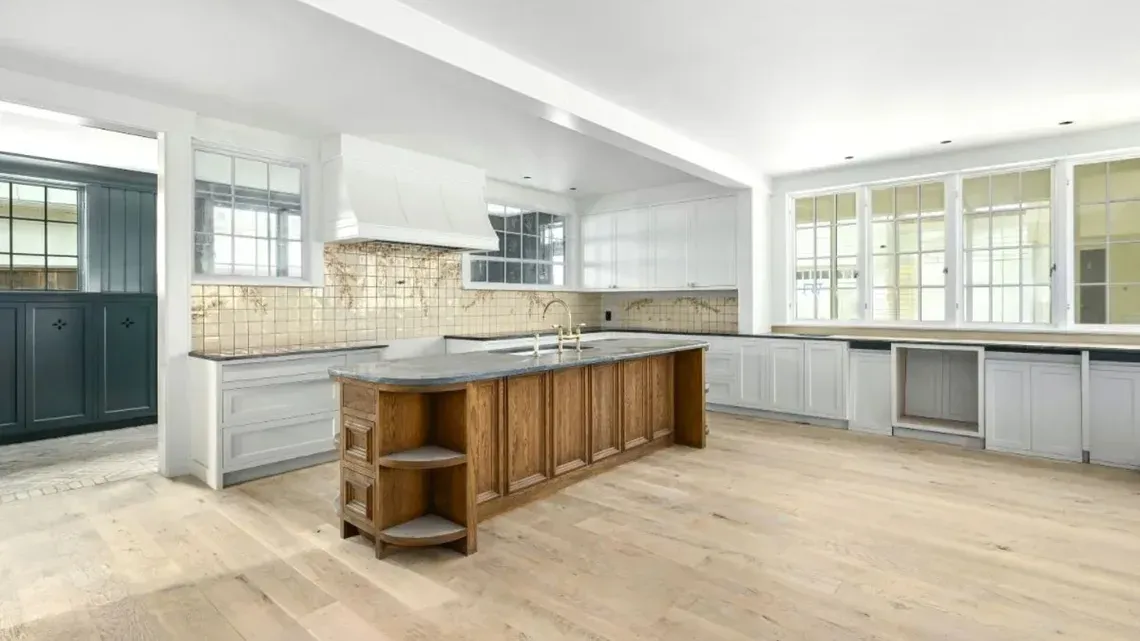 A kitchen featuring white finishes and timber accents