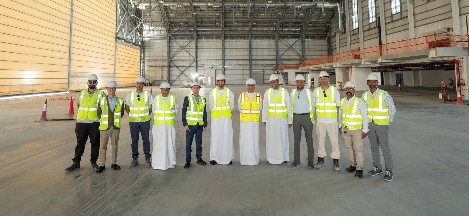 flydubai leadership and the project management team standing inside a heavy maintenance hangar at the airline's new Aircraft Maintenance Centre in Dubai South