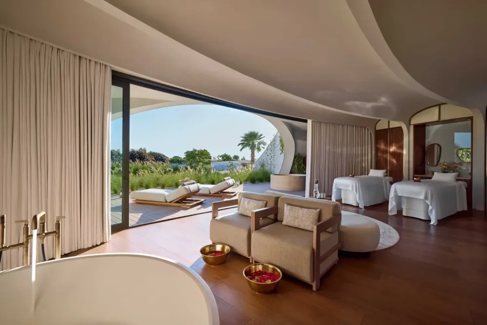 Studio Paolo Ferrari’s interiors highlight organically sculpted details, including monolithic bed platforms, carved oak vanities, and cantilevered mirrors set beneath softly curved ceiling planes.