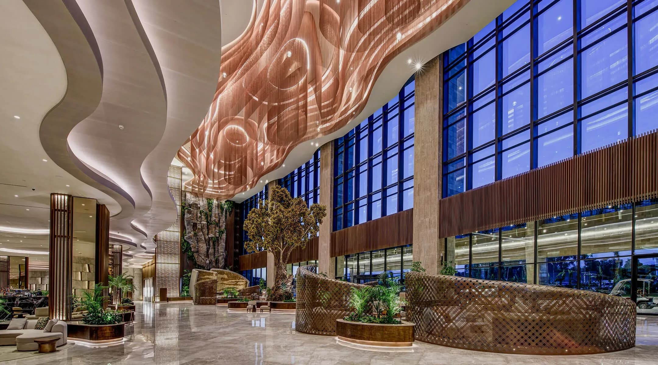 The resort's design approach draws inspiration from nature, with natural stone textures and organically shaped details used across the reception level and outdoor areas. 