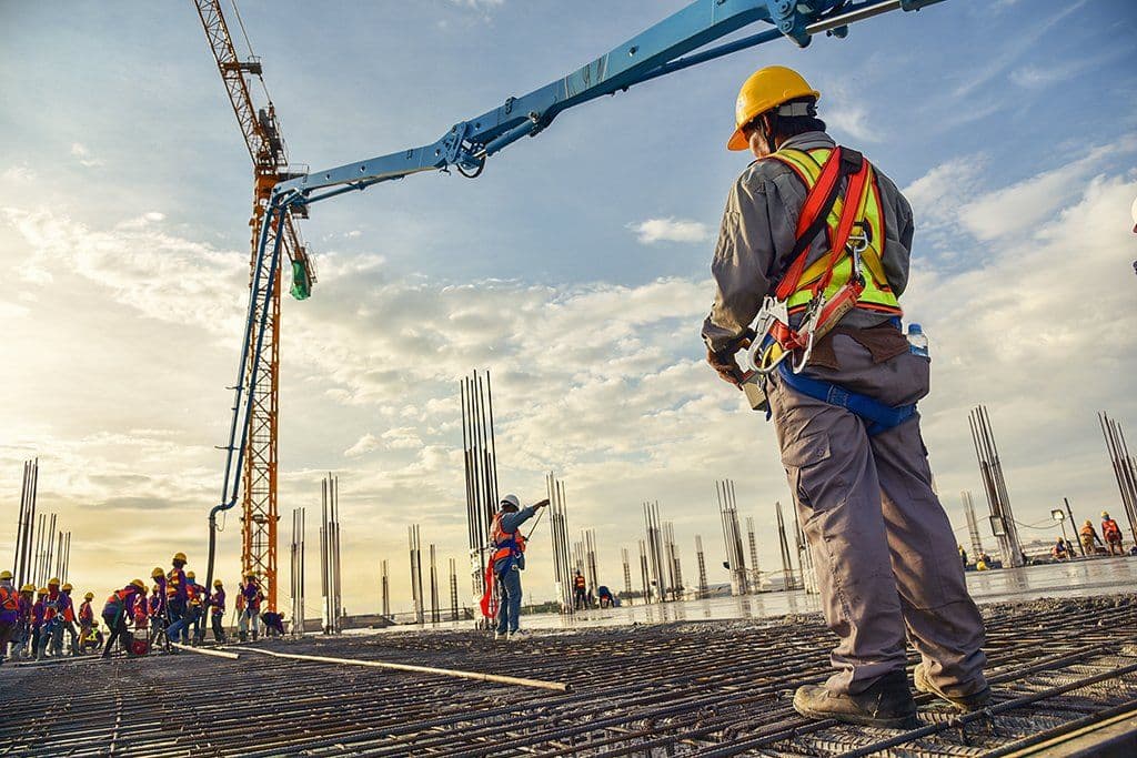 Workers and a concrete pump boom on a construction site, as Romania posts the EU’s fastest annual growth in construction output for August 2026