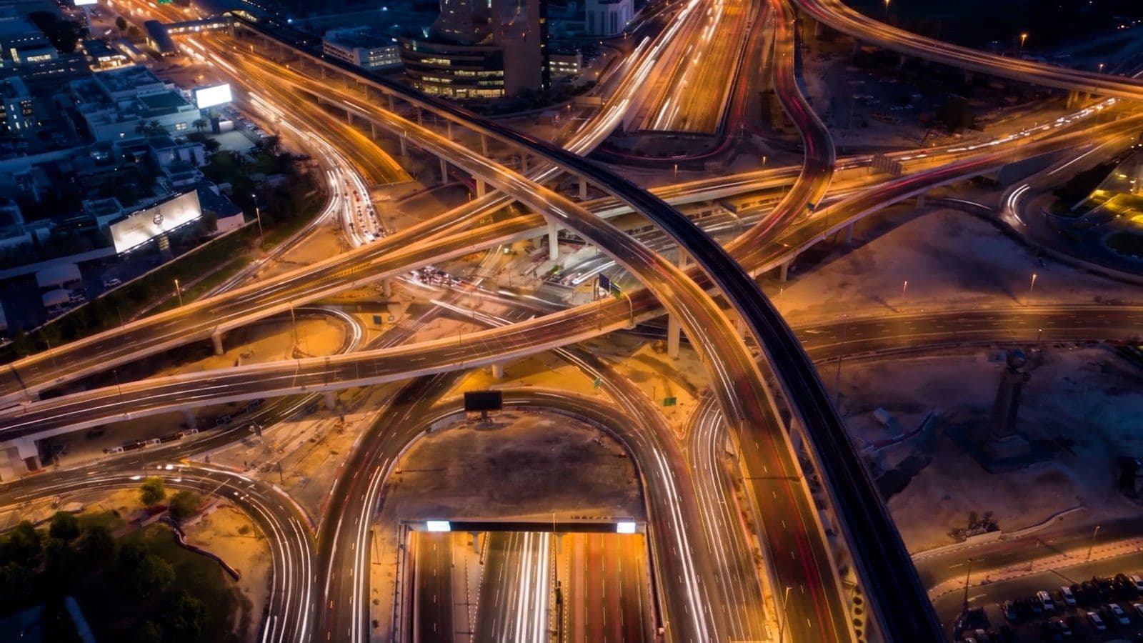 Night aerial view of the World Trade Centre Roundabout interchange on Sheikh Zayed Road in Dubai, with new bridges crossing the junction