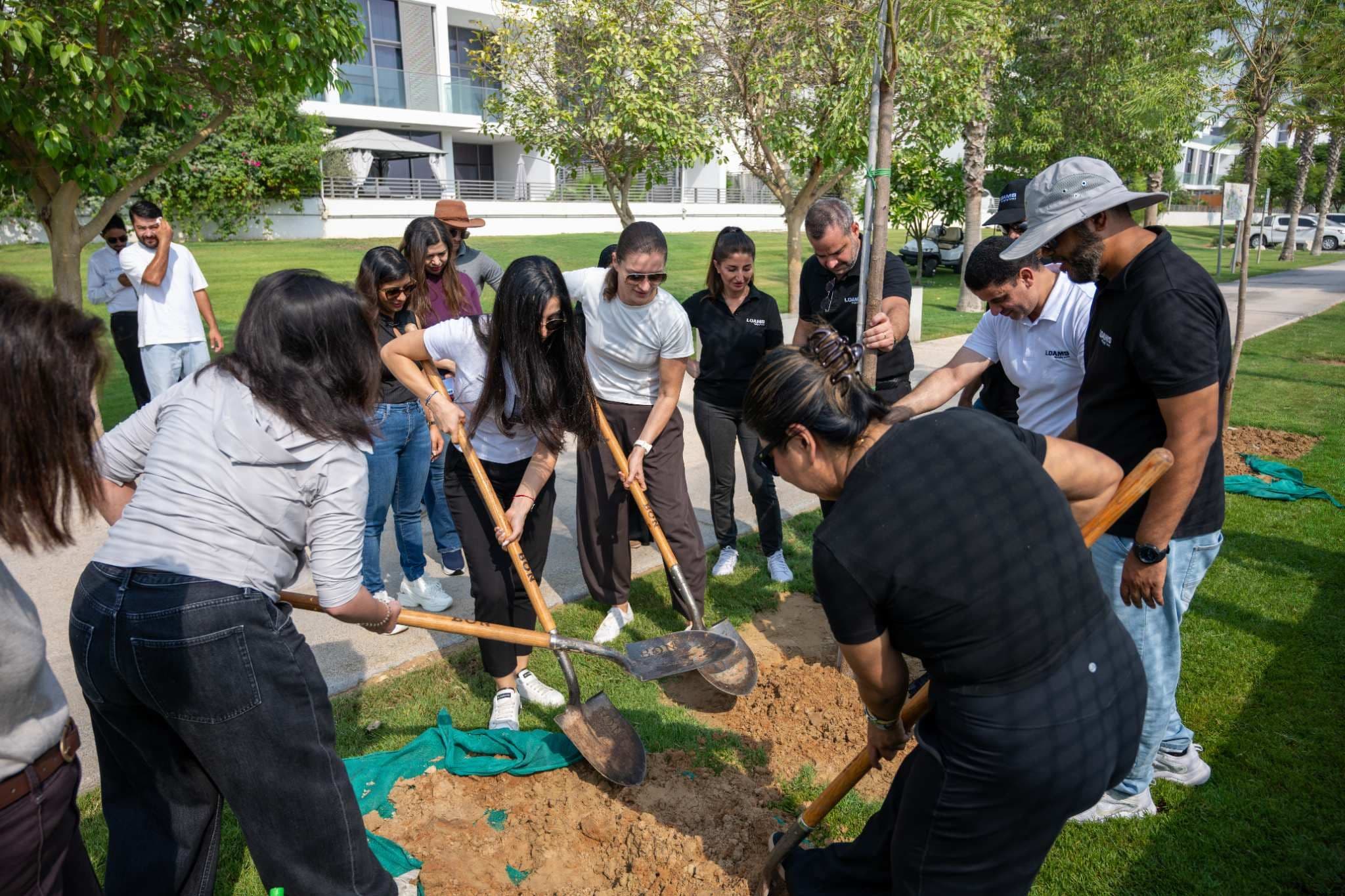 The DAMAC team planting flame trees across its communities