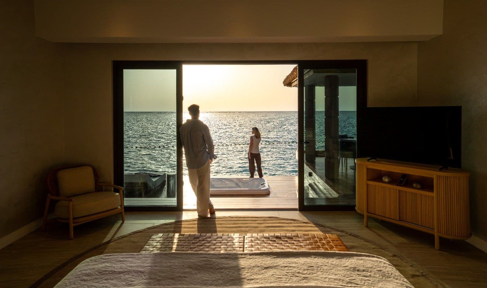 An overwater villa interior at Rixos Murjana opens directly towards the Red Sea through floor-to-ceiling glazing.
